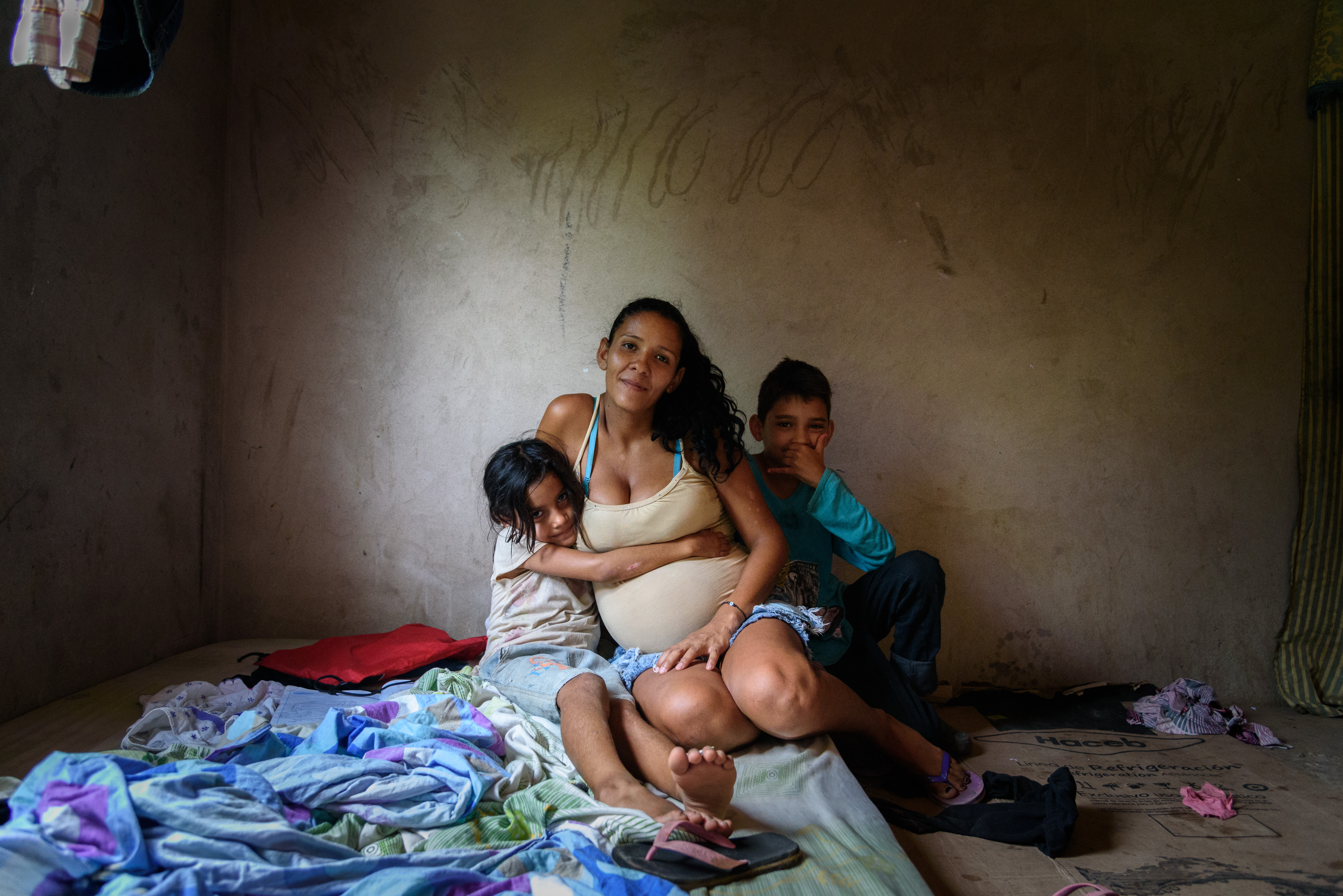 Woman with two children sitting on floor with blankets