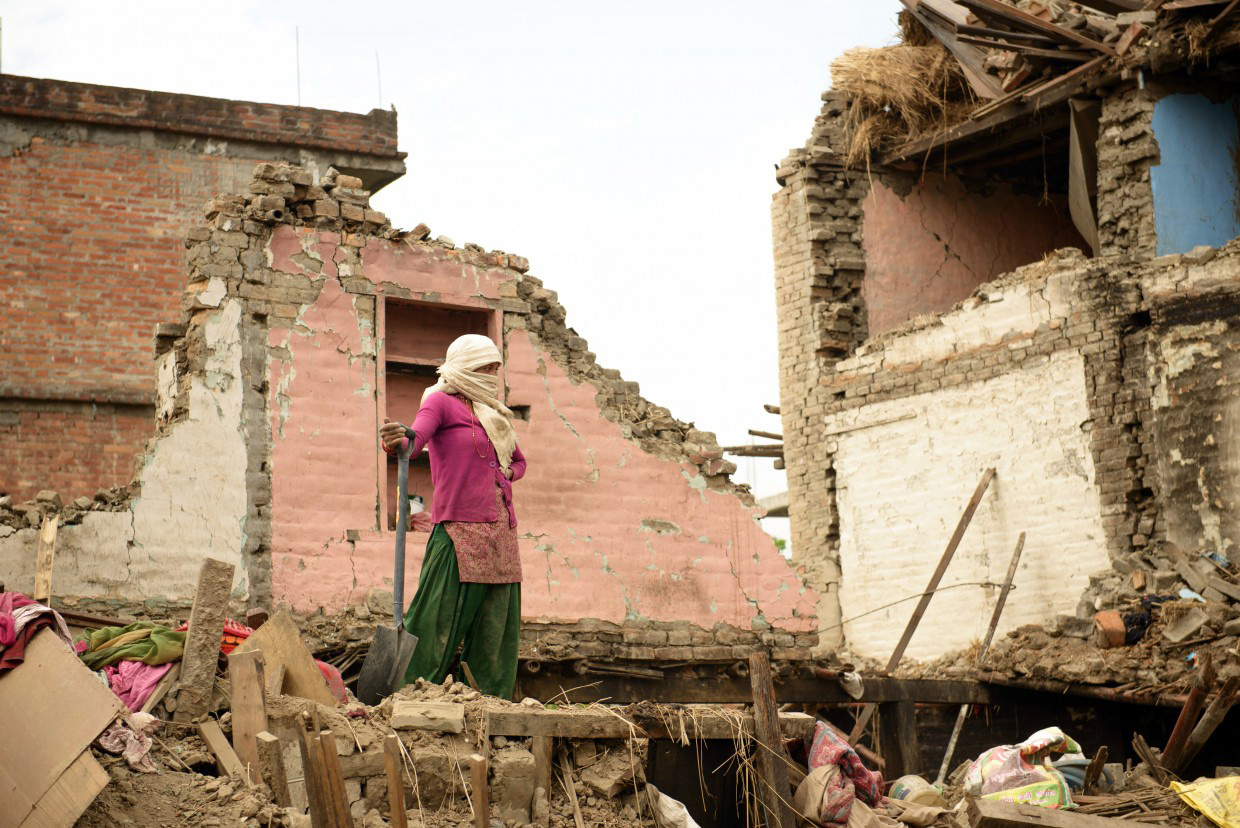 A woman in Nepal standing among rubble after the earthquake