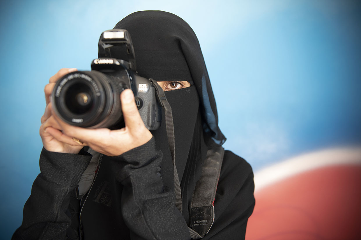 A woman holds a camera to her eye in Yemen