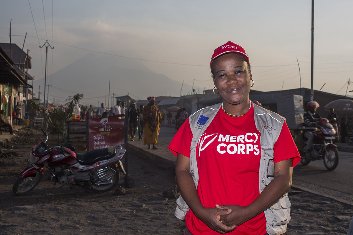 The DRC Director of Communications Odette poses for a picture in front of Mount Nyiragongo volcano.