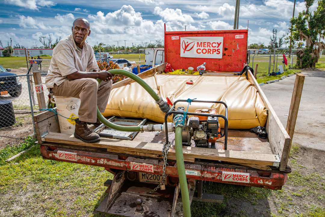 Mercy corps volunteer sitting on water truck in the bahamas after hurricane dorian.