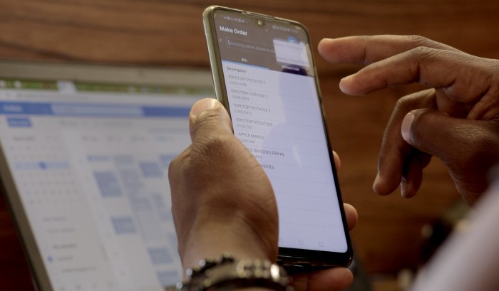 A pair of hands uses a mobile device.