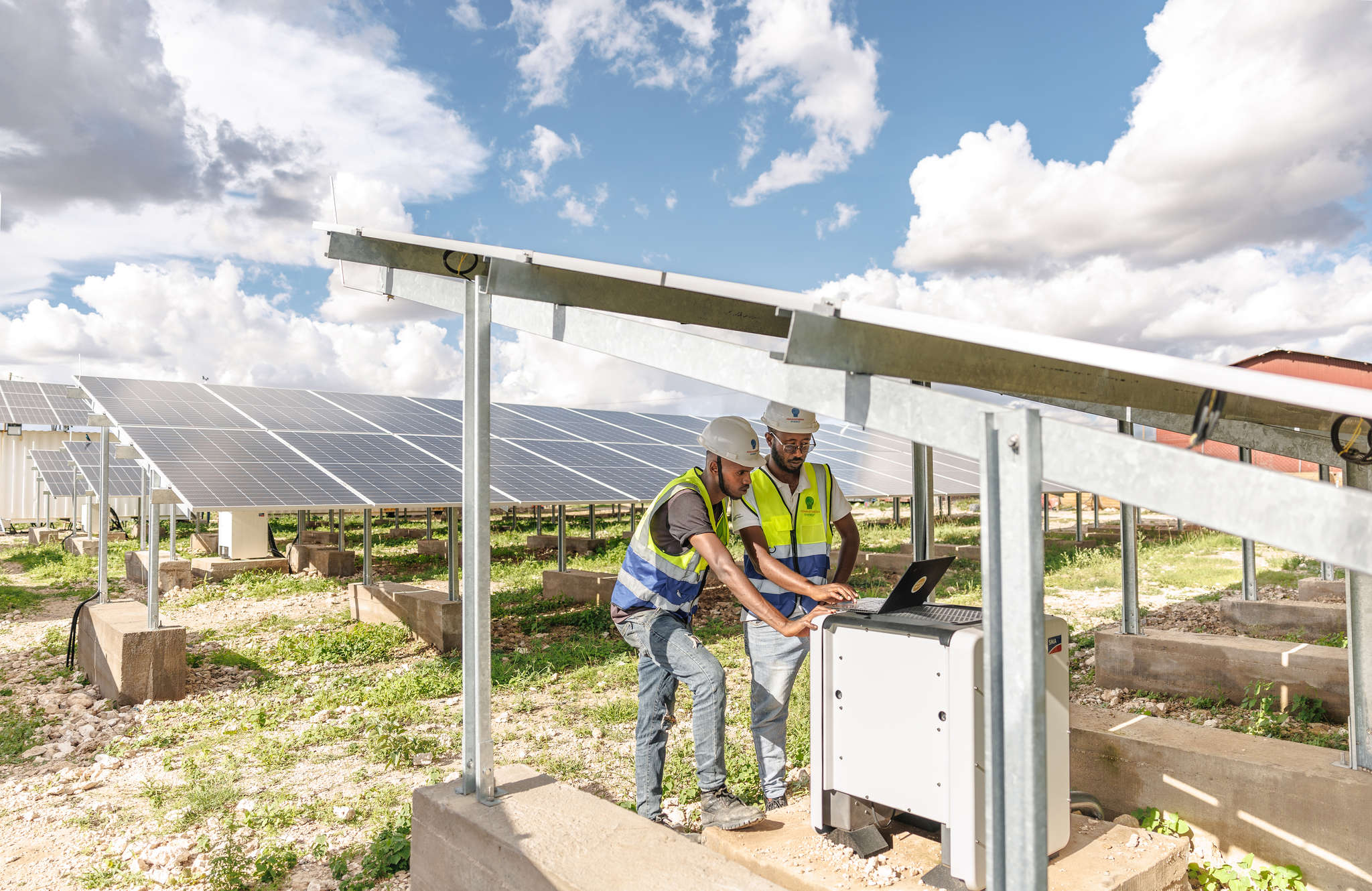 Two technicians work on a solar power plant in sheder refugee camp in ethiopia.