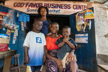 usan, 28, poses with her children, Mark, Neomi, and Sonny in front of her shop in Liberia.
