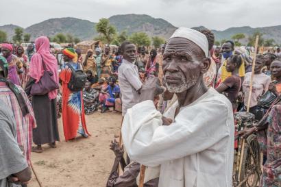 A crowd of people wait to receive food cards after registering as new arrivals at the Agiri internal displacement camp.