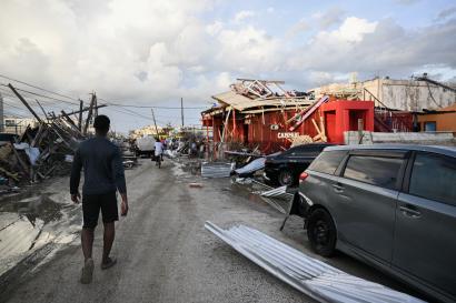 Jamaican walks through street and the Hurricane Melissa destruction.
