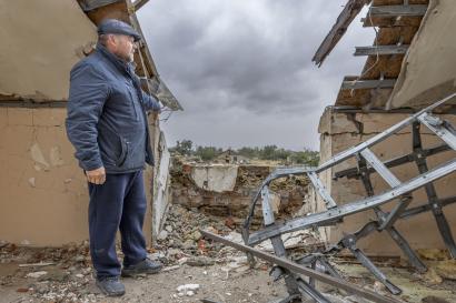 Ukrainian man stands amid rubble of a structure.