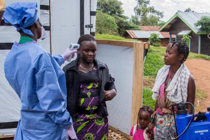 Congolese woman woman having temperature checked by medical staff.
