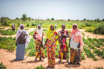 Women in niger standing in front of a field