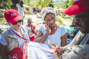 Mercy corps employees work with haitian woman