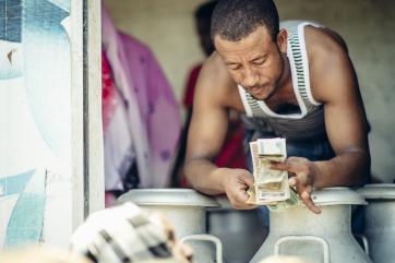A man counts out cash inside a milk truck in ethiopia