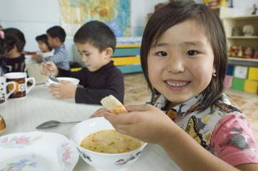 Children eating bread and soup in kyrgyzstan