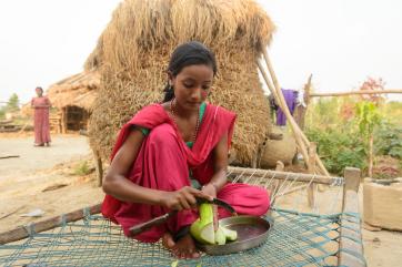 A teenage girl cutting vegetables in nepal