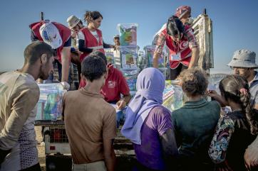 Syria team members handing supplies to people
