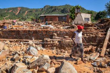 A woman walks among rubble in zimbabwe