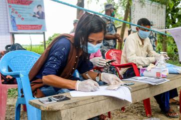 Nepalese woman filling out paperwork.