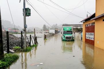 Semi truck navigates flooded guatemalan streets.