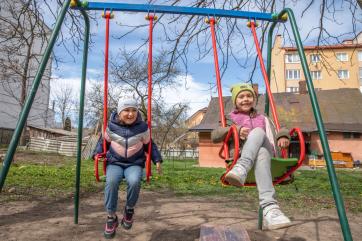 Two children enjoying a swing set.