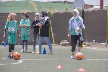 Jordanian girls on a soccer pitch together.