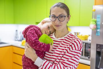Ukrainian mother and child in a community center kitchen area.