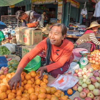 Woman selling fruit at an open air market in myanmar