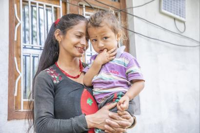 Sushma holds her 1 year-old son rashik in maneswora, nepal