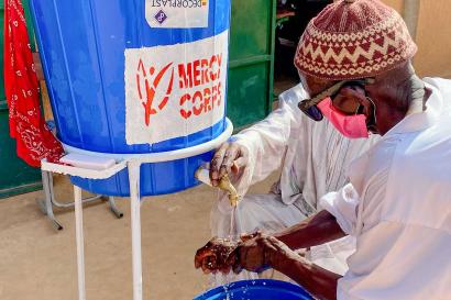 Niger man washed hands at portable washing station.