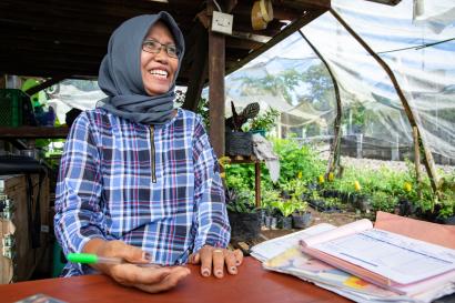 Plant nursery owner smiling at her desk in indonesia