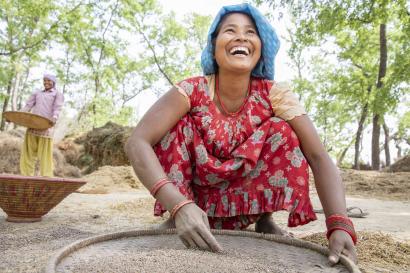 A person separates lentils from chaff.