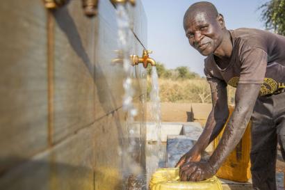 A person filling a jerry can with water.