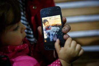 Young girl looking at photos of her family on a smartphone