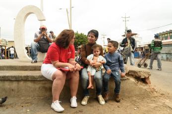 Mercy corps team member speaking to mother and two children in colombia