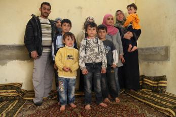 Abid with his wife and eight children in their one-room home.