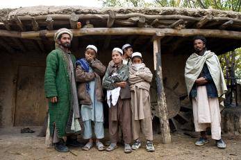 Men and boys standing under a covered porch in afghanistan