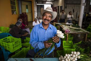 A man holding harvested vegetables in guatemala