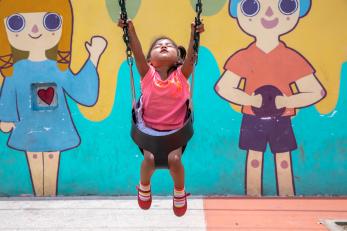 A young girl plays on a swing in guatemala