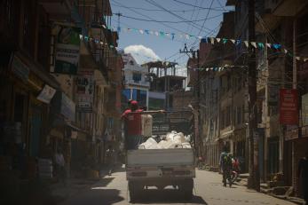 A truck with mercy corps team members navigates a city street in nepal
