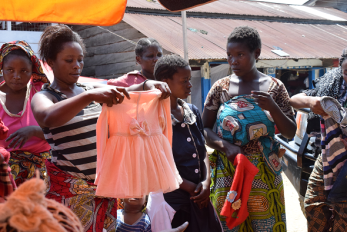 People looking at children's clothes in a street market in dr congo