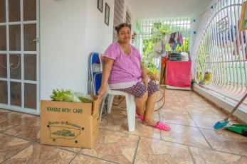 Woman sits in home porch.