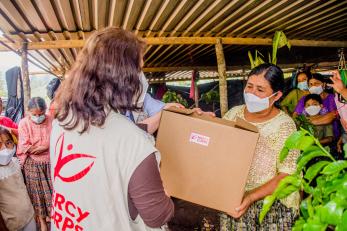 A mercy corps member hands a box of aid items to a person in alta verapaz in guatemala. 