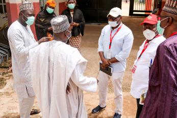 A small group of people stand together talking.