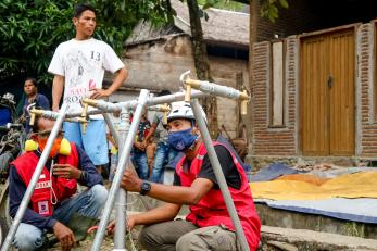 Indonesian emergency workers repairing water piping.