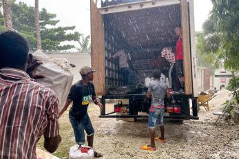 People unloading supplies from a truck.