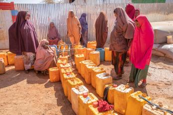 People fill jerrycans at a mercy corps water point at an idp camp near baidoa.