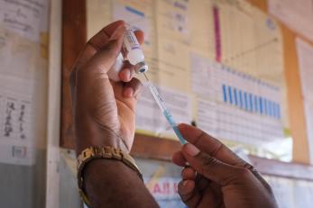 Hands of a medical professional preparing vaccine shot.