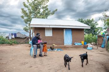 Ukrainian man and children happily interact outside a home.