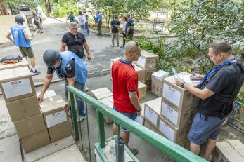 A mercy corps partner delivering emergency supply kits.