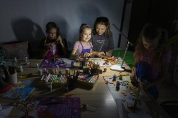 Ukrainian children attend art therapy in a mercy corps' partner's basement during a blackout.