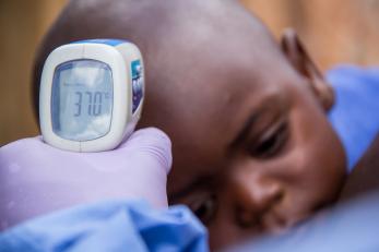 Congolese child having temperature checked by medical staff.