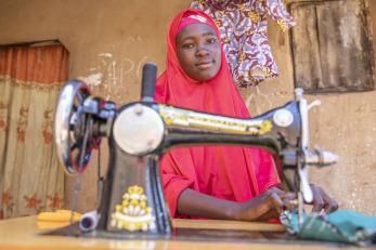 Nigerian woman at sewing machine.